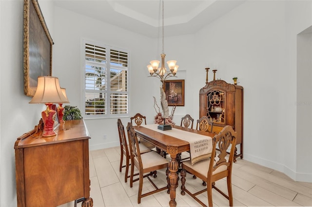 dining room with a tray ceiling and a notable chandelier