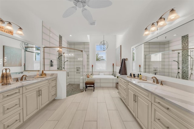 bathroom featuring ceiling fan, vanity, and independent shower and bath