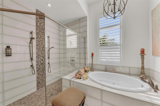 bathroom featuring an inviting chandelier and shower with separate bathtub