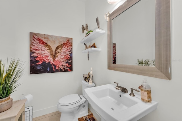 bathroom with toilet, tile patterned floors, and sink