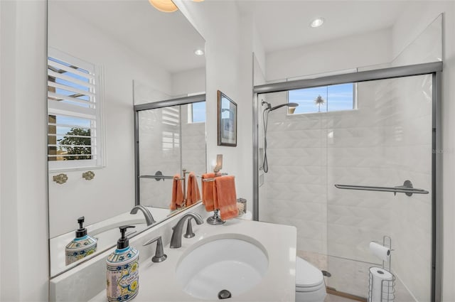 bathroom featuring toilet, a shower with door, and sink