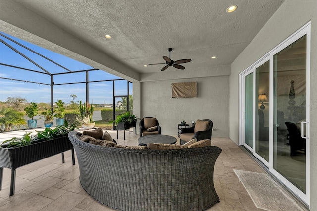 view of patio / terrace featuring ceiling fan, glass enclosure, and an outdoor living space