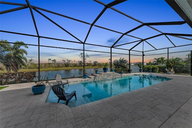 pool at dusk with a lanai, a water view, pool water feature, and a patio