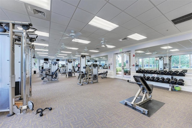 workout area with carpet floors, a paneled ceiling, crown molding, and ceiling fan