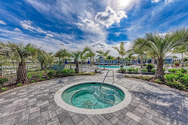 view of pool featuring a hot tub and a patio