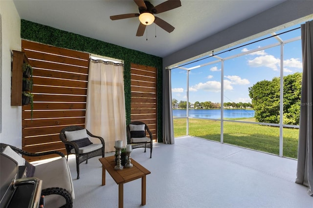 sunroom / solarium featuring ceiling fan and a water view