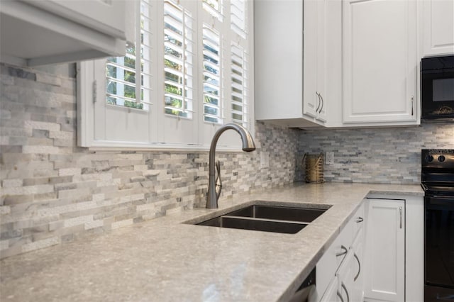 kitchen featuring white cabinetry, sink, light stone countertops, tasteful backsplash, and black appliances