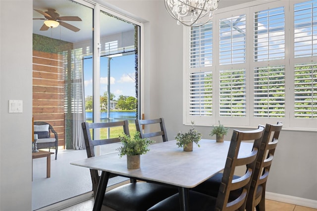 dining area featuring a water view and ceiling fan