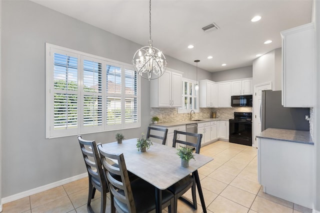 dining space featuring light tile patterned flooring, a chandelier, and sink