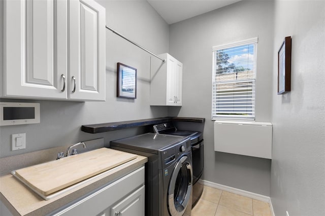 laundry area with cabinets, light tile patterned floors, and washer and dryer