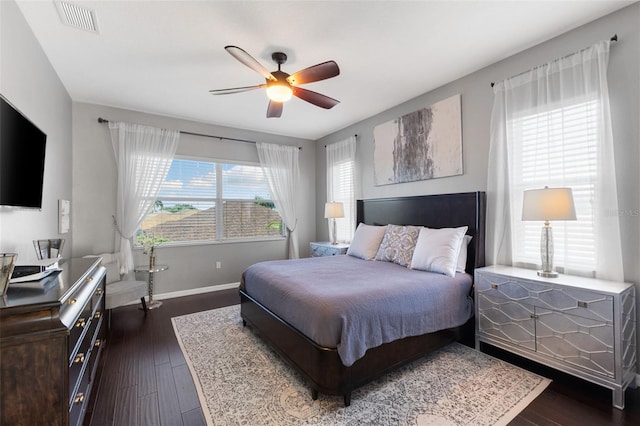 bedroom with dark hardwood / wood-style flooring, multiple windows, and ceiling fan