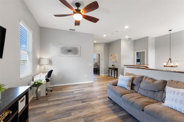 living room featuring hardwood / wood-style floors and ceiling fan with notable chandelier