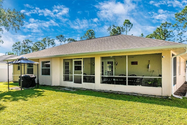 rear view of property with a sunroom and a yard