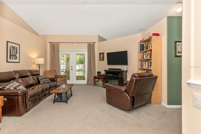 living room with french doors, light colored carpet, and vaulted ceiling