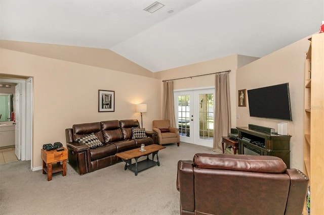 living room with vaulted ceiling, light carpet, and french doors