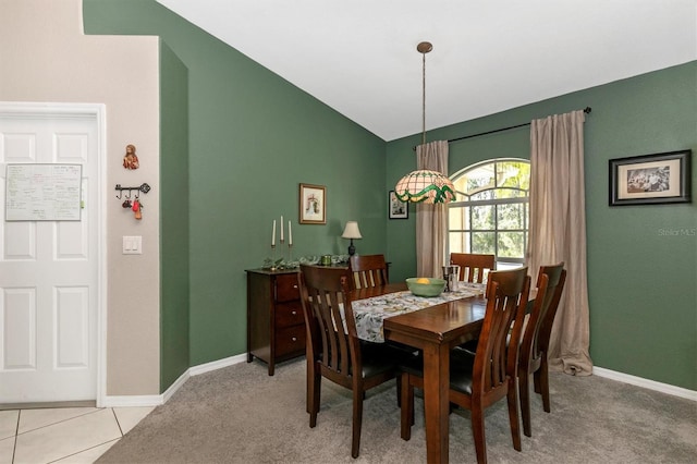 dining area with lofted ceiling and light colored carpet