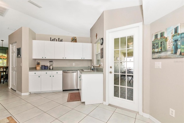 kitchen featuring light tile patterned flooring, sink, white cabinets, lofted ceiling, and stainless steel dishwasher