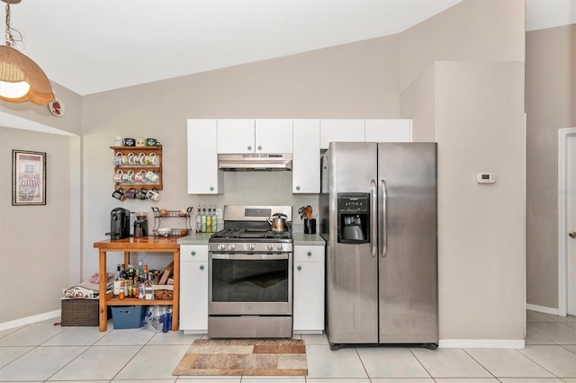 kitchen with white cabinets, pendant lighting, light tile patterned floors, stainless steel appliances, and vaulted ceiling