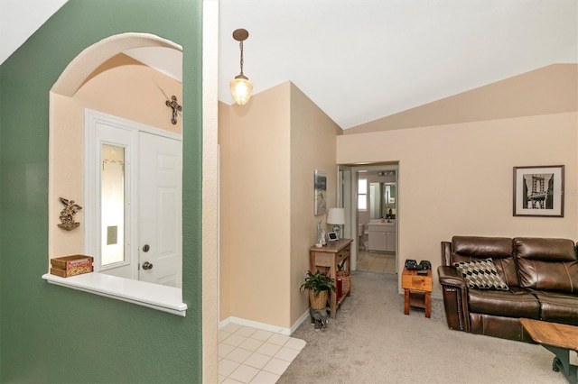 carpeted entryway featuring vaulted ceiling