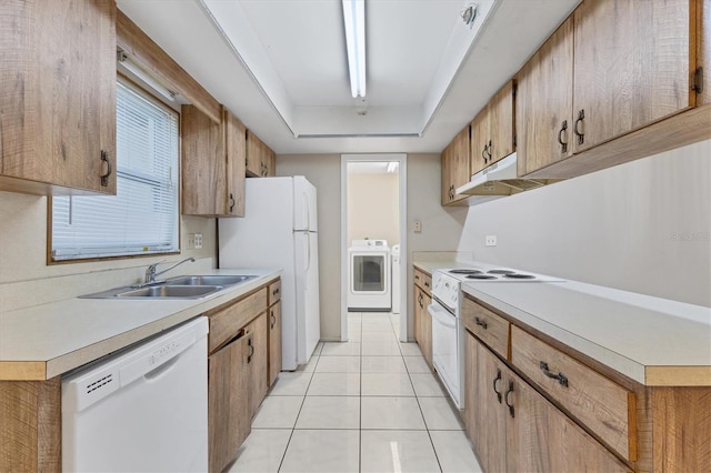 kitchen featuring light tile patterned flooring, a raised ceiling, sink, white appliances, and washer / dryer