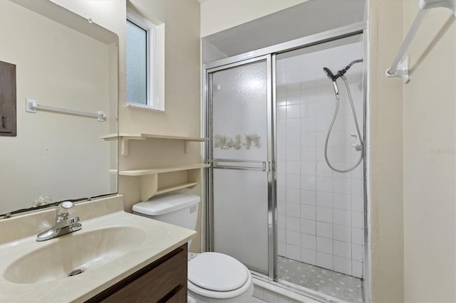 bathroom with vanity, toilet, and a shower with shower door