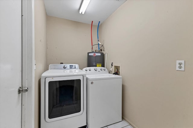 laundry area with light tile patterned floors, water heater, and washer and dryer