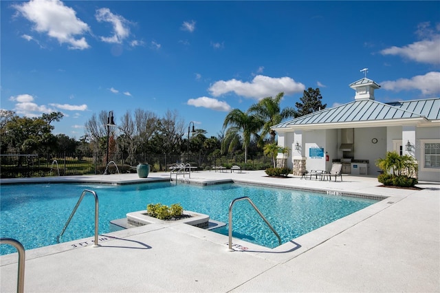 view of swimming pool with area for grilling and a patio area