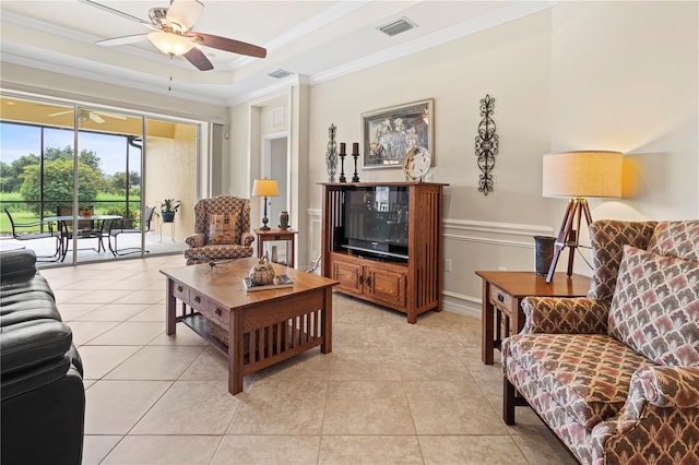 tiled living room featuring a tray ceiling, ceiling fan, and crown molding