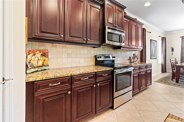 kitchen with appliances with stainless steel finishes, decorative backsplash, light tile patterned flooring, light stone countertops, and ornamental molding