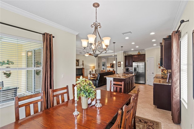 dining space featuring ornamental molding, an inviting chandelier, light tile patterned floors, and sink