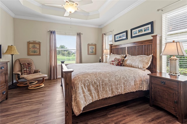 bedroom featuring crown molding, dark hardwood / wood-style floors, ceiling fan, and a raised ceiling