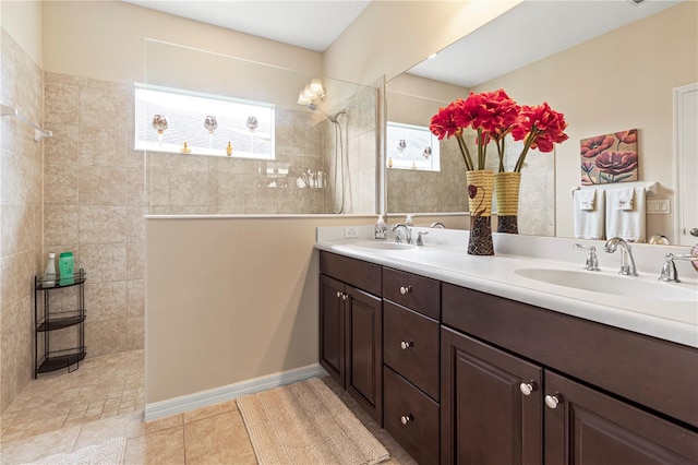 bathroom featuring a tile shower, tile patterned flooring, and vanity