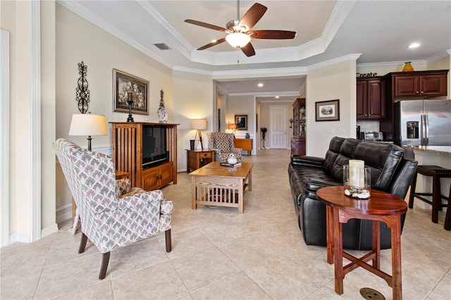 living room featuring crown molding, a tray ceiling, light tile patterned floors, and ceiling fan