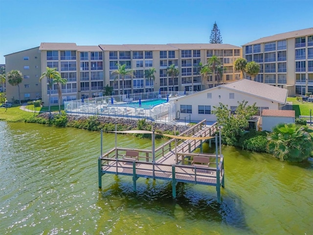 view of dock with a water view and a community pool