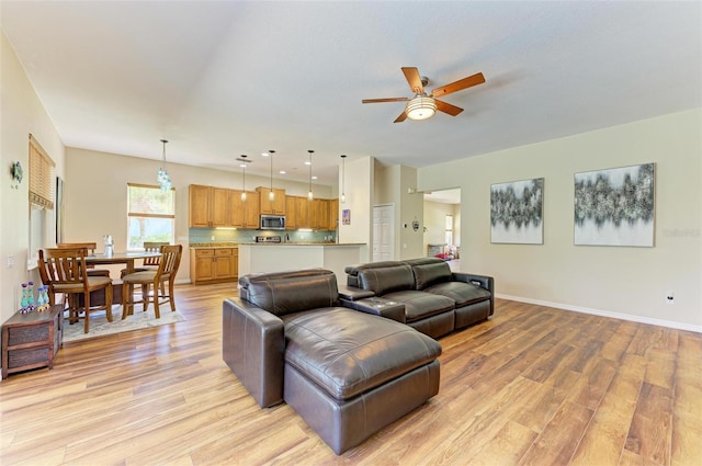 living room with light hardwood / wood-style flooring and ceiling fan