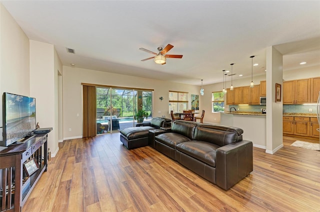 living room featuring ceiling fan and light wood-type flooring