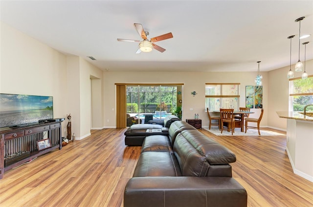 living room with ceiling fan and light hardwood / wood-style flooring