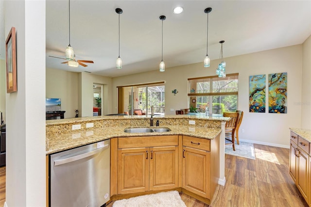 kitchen with light stone countertops, light wood-type flooring, ceiling fan, stainless steel dishwasher, and sink