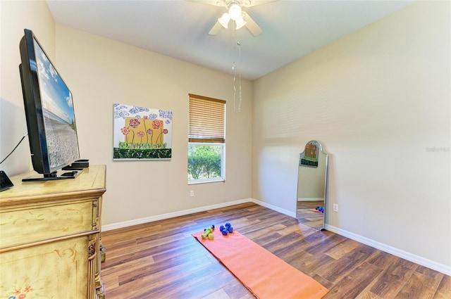 exercise area with dark hardwood / wood-style floors and ceiling fan