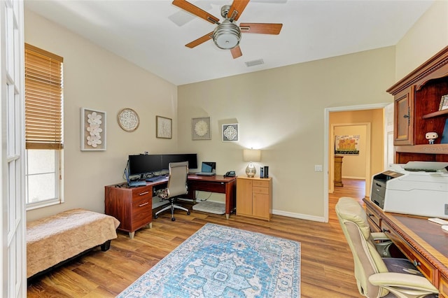 office with light hardwood / wood-style floors and ceiling fan