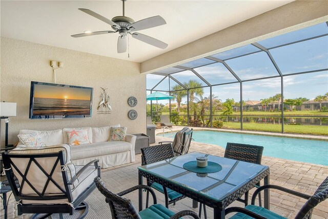 view of patio / terrace with a lanai, an outdoor hangout area, a water view, and ceiling fan