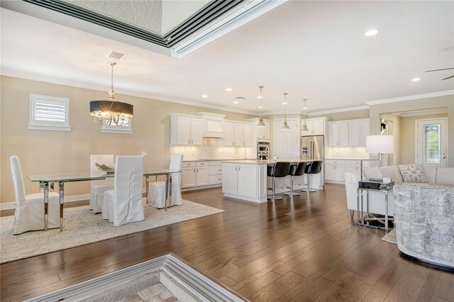 dining room featuring ornamental molding, an inviting chandelier, and dark hardwood / wood-style flooring