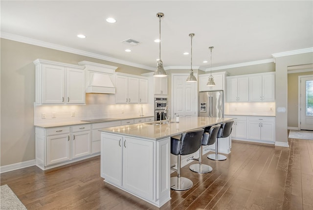 kitchen featuring white cabinets, premium range hood, and appliances with stainless steel finishes