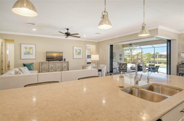 kitchen with ceiling fan, hanging light fixtures, sink, and crown molding