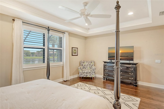 bedroom featuring a raised ceiling, crown molding, ceiling fan, and hardwood / wood-style flooring