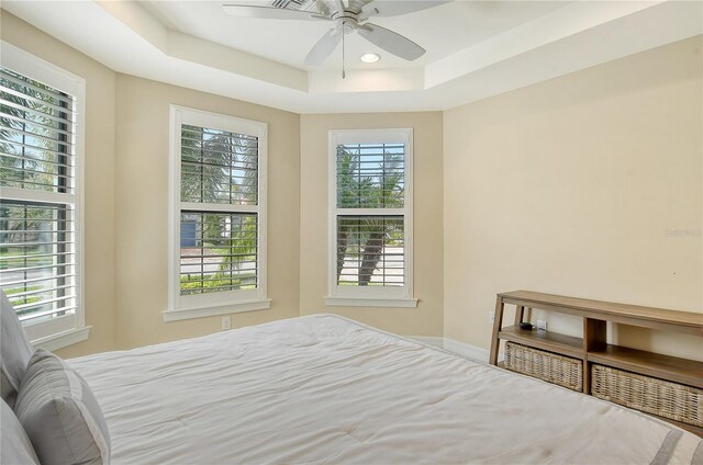 bedroom with ceiling fan and a raised ceiling