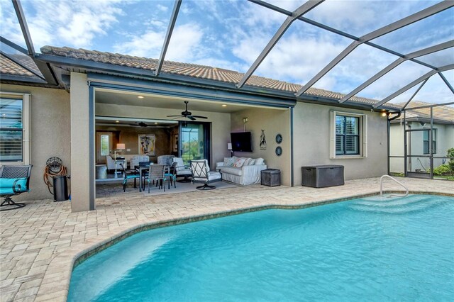 view of pool with ceiling fan, an outdoor hangout area, glass enclosure, and a patio area