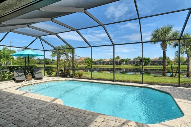 view of swimming pool with a patio, glass enclosure, and a water view