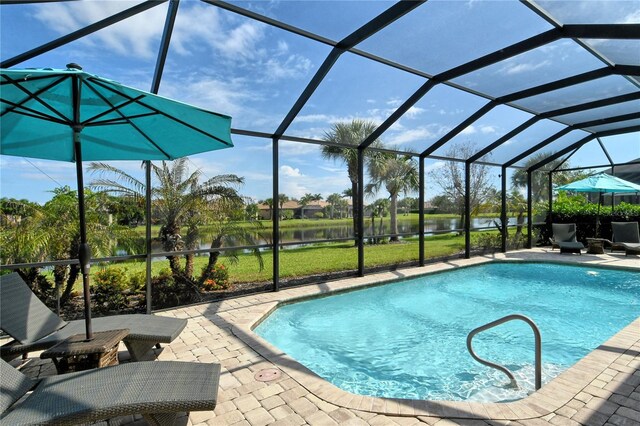 view of pool featuring a patio, a water view, and glass enclosure