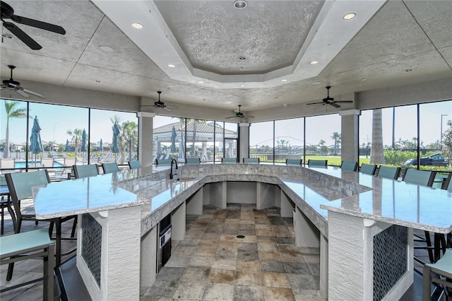 interior space with light stone countertops and ceiling fan